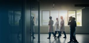 hospital medical staff walking down a corridor during late afternoon or early morning