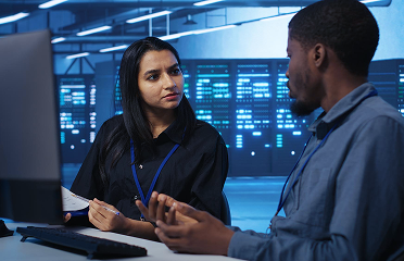 Two technicians consult over security and privacy concerns in a healthcare organization server room