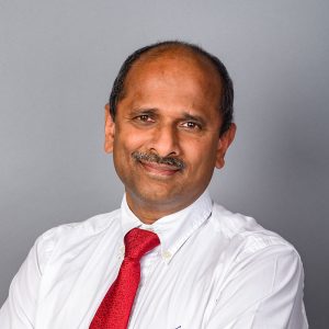 Ilanko Kumaresan, CEO of Genzeon, formal headshot wearing red tie, no jacket